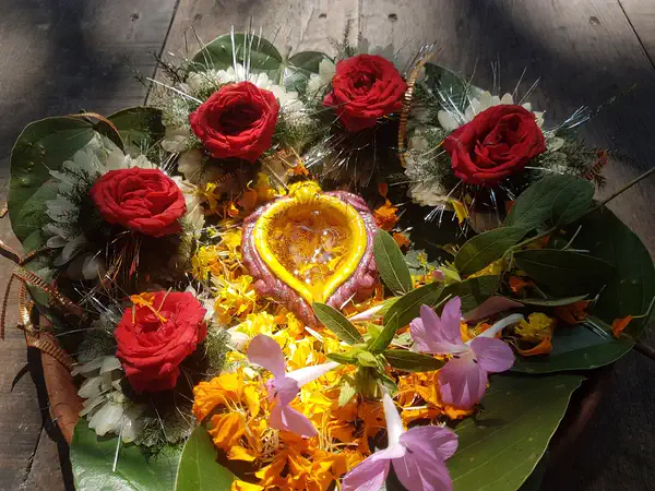 Marigold and rose flower offering with a diya