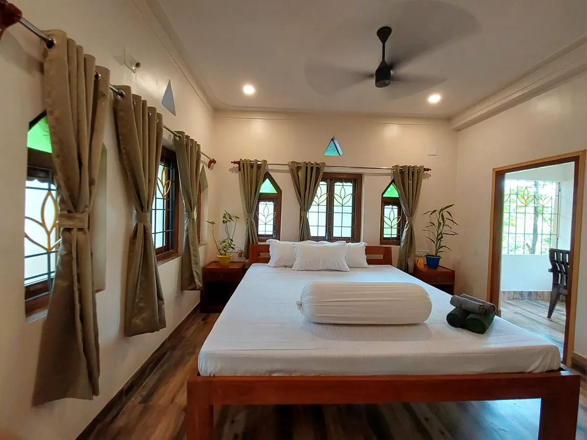 Deluxe room with a large bed and curtained windows